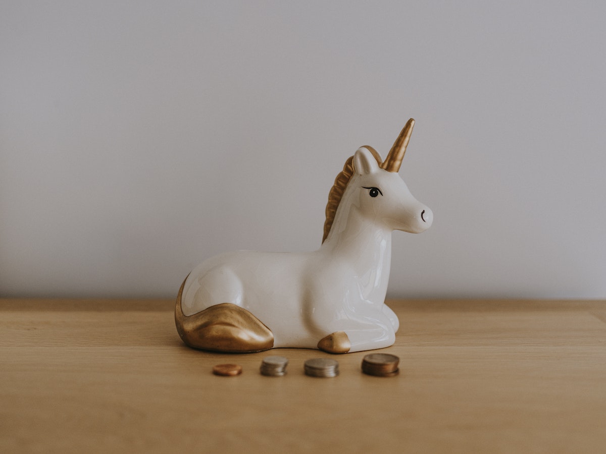 A small unicorn statue sitting on a table with spare change